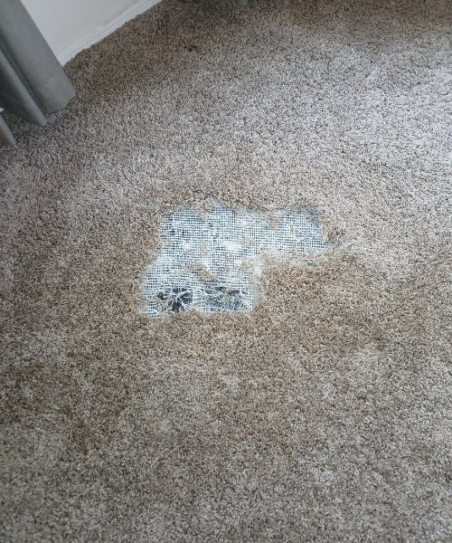 A dirty carpet with a hole in the middle of it