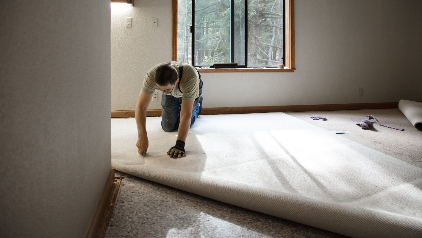 A man kneeling down on the floor of a room