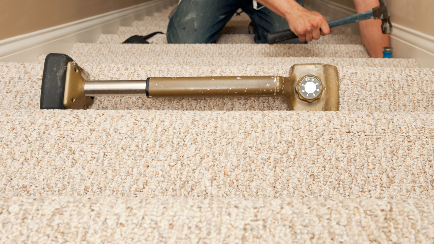 A man using a vacuum to clean a carpet