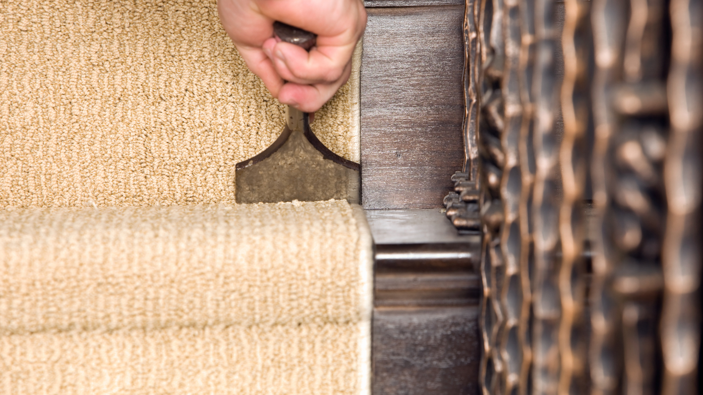 A person holding a piece of metal on top of a rug